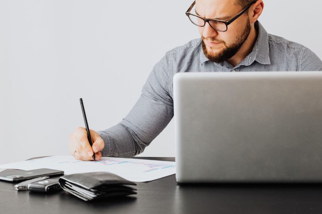 Financial researcher working on a laptop while preparing educational personal finance content for Primfi Media